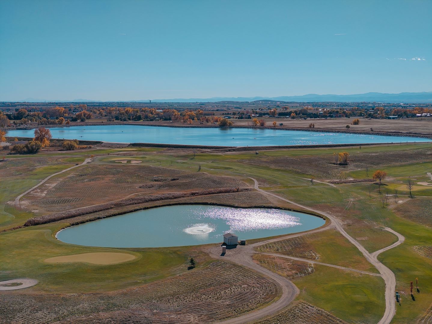 A landscape of a golf course with a lake