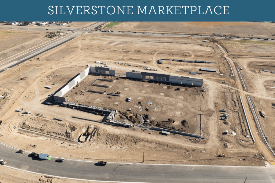 Aerial view of Silverstone Marketplace with roads, a monument sign, and an expansive snowy field
