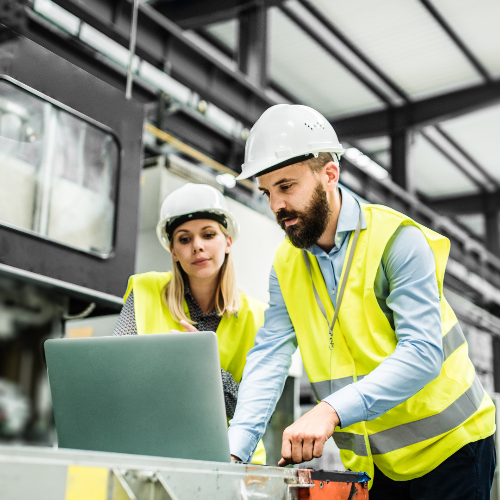 Two construction workers looking at a computer