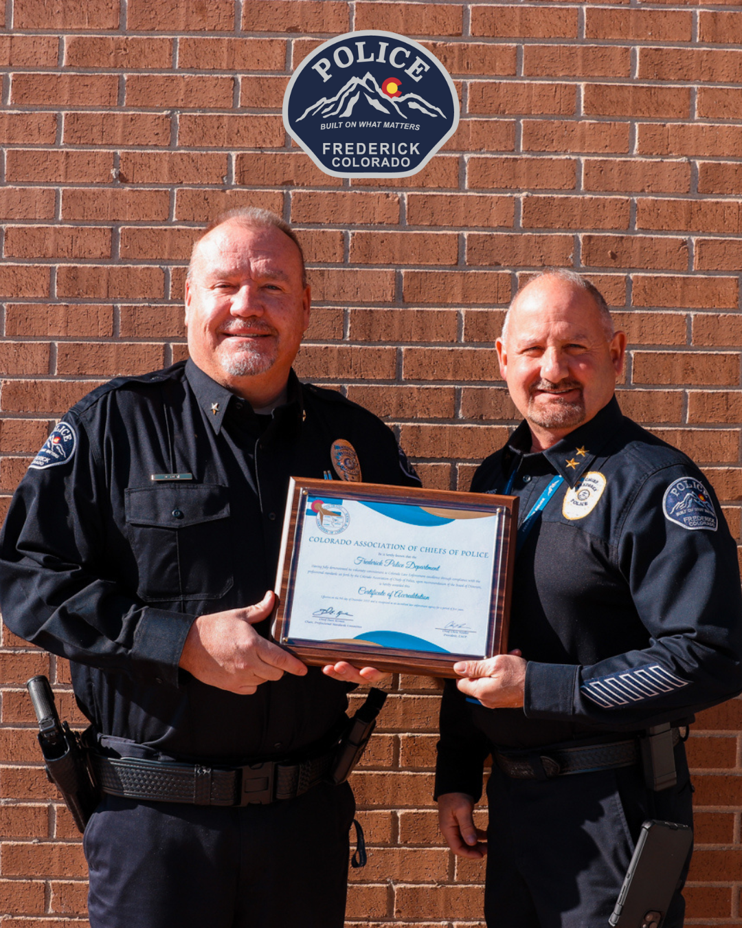 Frederick Police Chief stands next to Frederick Police Officer holding an accreditation plaque