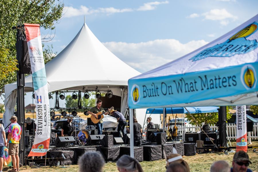 Outdoor stage performance at Miners Day with banners and crowd in view.