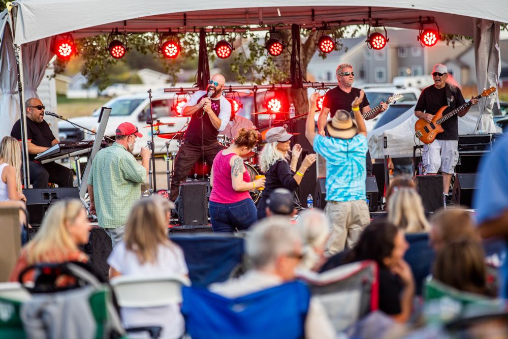 A live band performs on stage as attendees dance and enjoy the music.